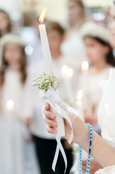 Children hold candles during a religious ceremony in a church, celebrating an important event. Communion