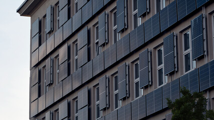 Modern apartment building with geometric facade, balconies and windows against blue sky for real estate, residential architecture and urban housing themes © Jacek