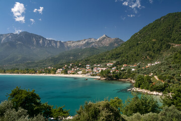 Obraz premium Scenic coastal view of the turquoise sea and white sandy bay of Chrysi Ammoudia on Thasos island below green mountains