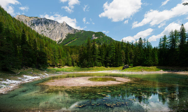 Crystal clear water of Gruner See with reflections in the Austrian Alps, capturing a pristine alpine lake landscape in spring