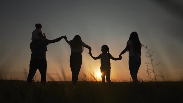 Family holding hands silhouette sunset outdoor togetherness bonding parents children unity love connection. Parents with children form circle holding hands. Family bonds during sunset. Unity outdoors.