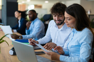 Fototapeta premium Diverse business team collaborating and discussing documents in office