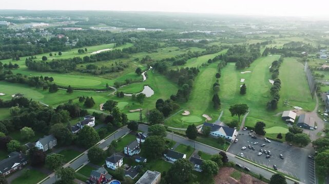 Wide drone shot of a golf course in Truro, Nova Scotia moving left in a smooth circular motion, expansive aerial view of rolling fairways and greens, cinematic landscape, peaceful outdoor atmosphere