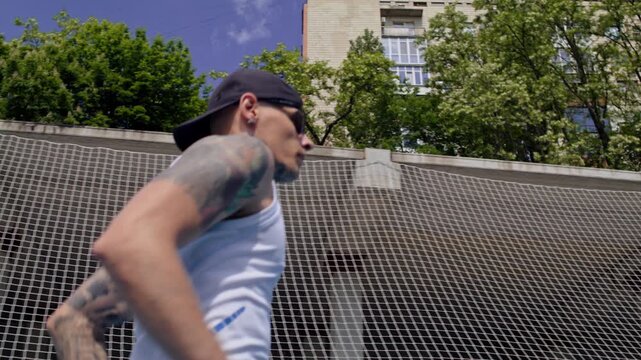 Male athlete with bionic leg prosthesis jogs on stadium track