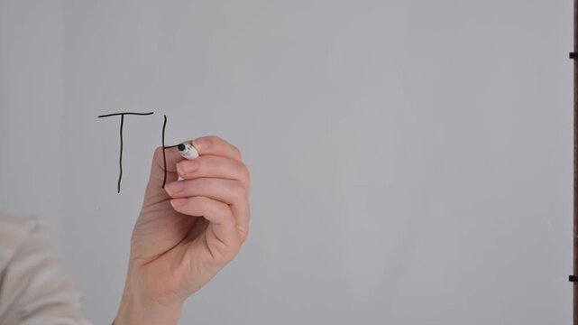 A woman writes the phrase the end on a transparent glass.