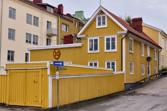 Karlskrona, Sweden - 14 September 2025: View of traditional yellow wooden architecture and street scenes in the historic naval city, featuring a two-story house with white window frames.
