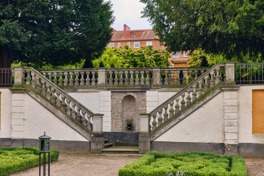 Karlskrona, Sweden - 14 September 2025: View of the symmetrical stone staircase with balustrades in Grevagardens barocktradgard, featuring manicured hedges and lush trees.