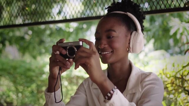 Cheerful young woman taking pictures with digital camera