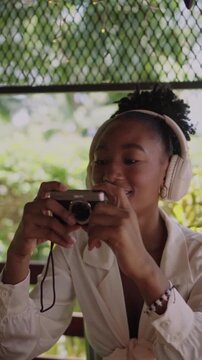 African american woman taking photos with vintage camera