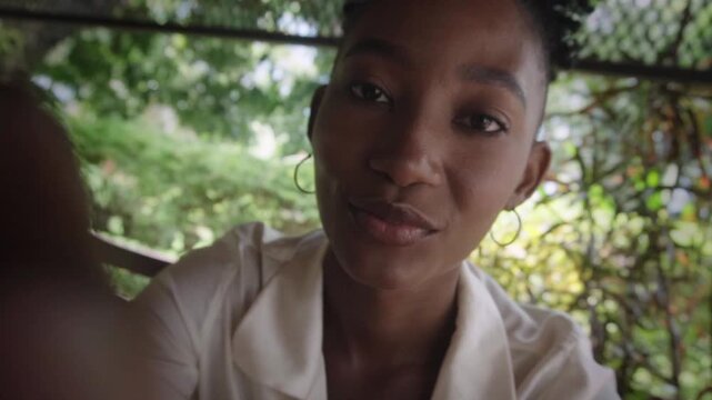 African woman making a selfie video call outdoors