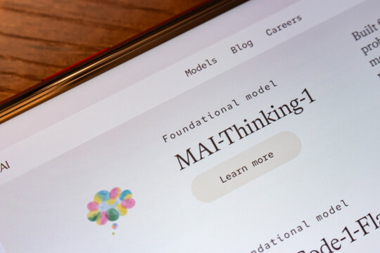Mexico City, MEXICO - Jun 16 2026 : Close-up of a smartphone displaying the Microsoft AI website showing MAI-Thinking-1, the foundational reasoning model, on a dark wooden surface.