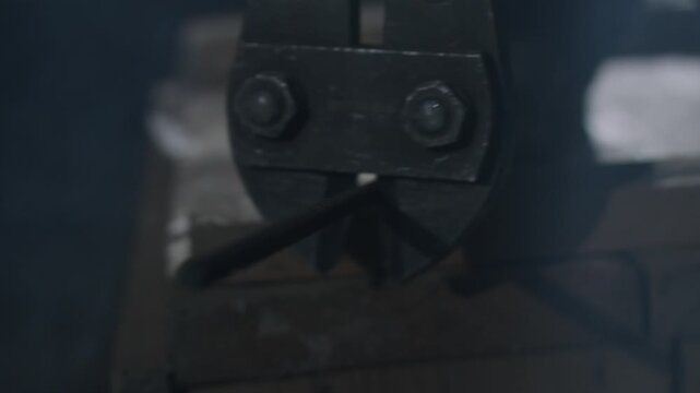 Closeup bolt cutter jaws cutting chain on workbench, gritty workshop mood, focused metal compression and mechanical force, oil