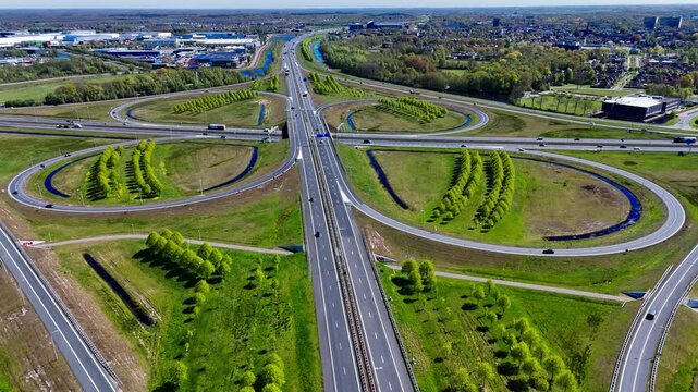 Aerial drone view road junction. Clover roundabout view from above. Car traffic on autobahn Netherlands. High quality 4k footage
