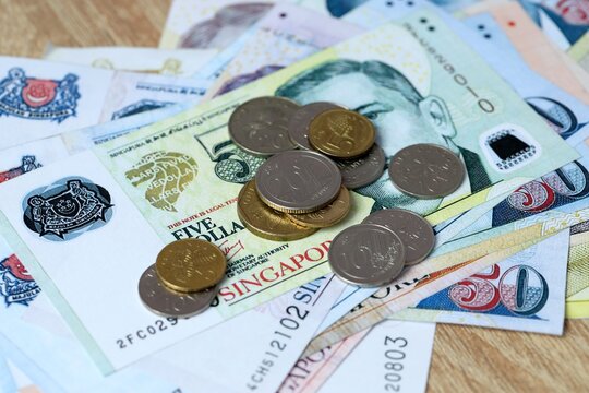Singapore dollar money bills and coins on table. Singapore cash of SGD currency close up