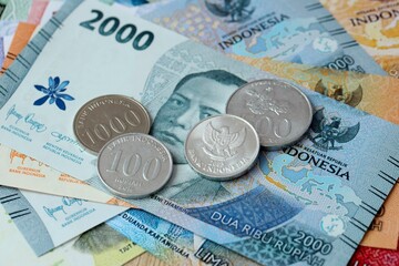 Indonesian rupiah money bills and coins on table. Indonesia cash of IDR currency © Larysa