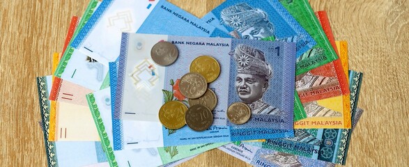 Malaysian ringgit money bills and coins on table. Malaysia cash of MYR currency close up © Larysa
