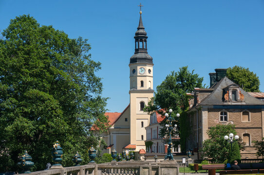 Church of All Saints (kości&oacute;ł Wszystkich Świętych) in background. Upper storey of tower is octagonal with clock. Pszczyna, Poland.