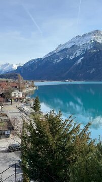 Beautiful turquoise lake and scenic waterfront town with majestic snow capped alpine mountains in the background