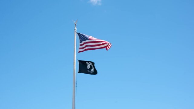 American flag and POW MIA flag waving on flagpole