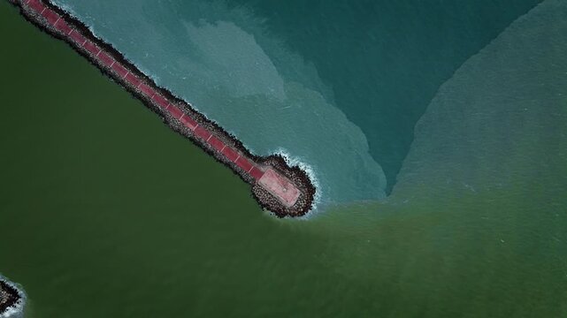 Aerial zenith drone shot of Miramar Beach breakwater in Tamaulipas, where the Panuco River meets the Gulf of Mexico, creating a striking natural color division between fresh and salt water