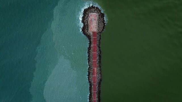 Aerial zenith drone shot of Miramar Beach breakwater in Tamaulipas, where the Panuco River meets the Gulf of Mexico, creating a striking natural color division between fresh and salt water