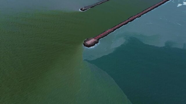 Aerial zenith drone shot of Miramar Beach breakwater in Tamaulipas, where the Panuco River meets the Gulf of Mexico, creating a striking natural color division between fresh and salt water