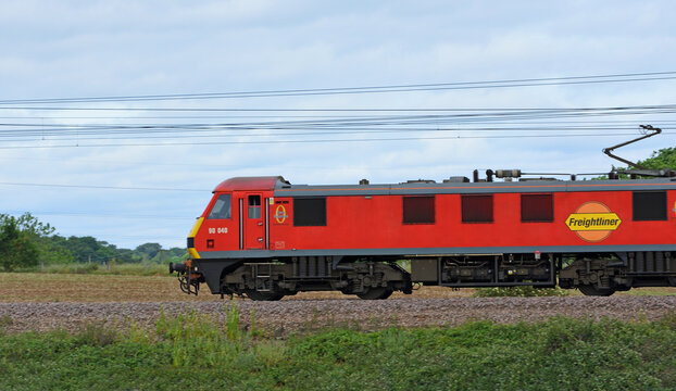 Red Freightliner goods train moving, side view