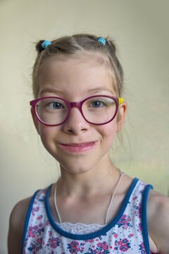 Close-up portrait of a girl wearing glasses looking at camera
