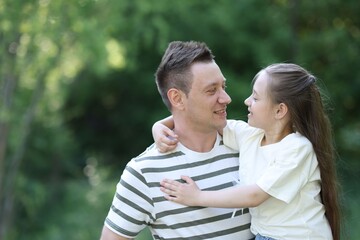 Obraz premium Smiling father and his daughter outdoors. Space for text