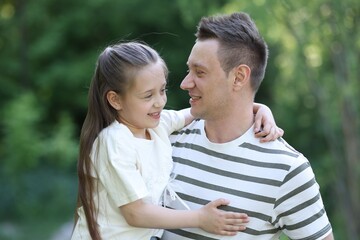 Fototapeta premium Smiling father and his daughter spending time together outdoors