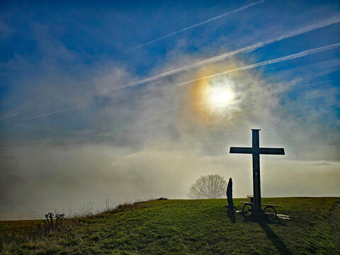Beautiful photos of a landscape shrouded in fog and a sunset, featuring trees and crosses