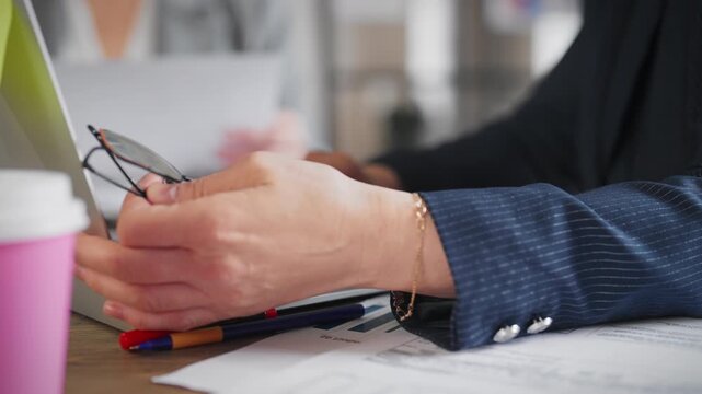 Woman boss in meeting with employees and investors, closeup view of female hands . Senior women in office of modern international company, workplace in boardroom, emotional gesticulating by hands