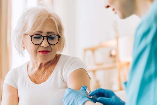 Senior woman receiving vaccine injection from nurse