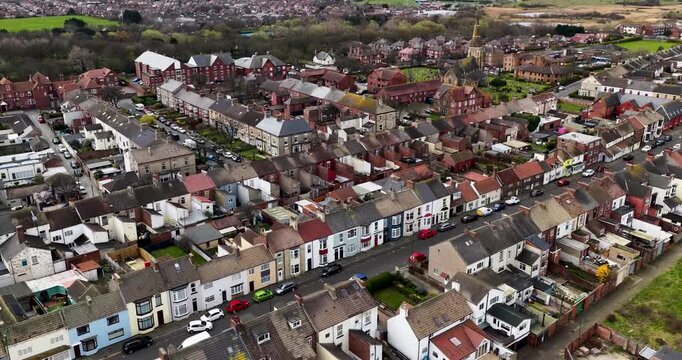 Aerial view of residential streets in Redcar Middlesbrough UK showing terraced housing church and graveyard with roads cars green spaces and railway lines in a typical UK town setting in the spring
