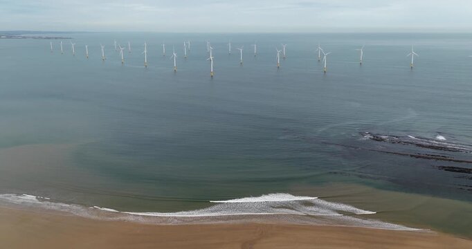 Aerial view of offshore wind turbines near Redcar and Middlesbrough on the North East coast of England showing sandy beach gentle waves coastal waters sandy beach and renewable energy infrastructure