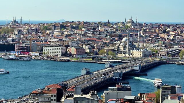 a video panorama of the eminonu area inside of the historic city of istanbul turkiye, with the bridge and mosques on the site and urban area.