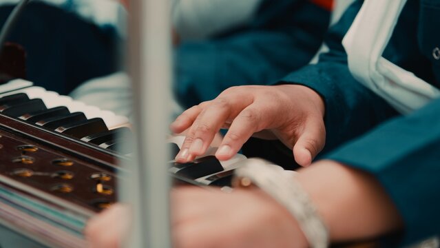 Indian child hands plays Sikh prayer music with harmonium keyboard during Vaisakhi