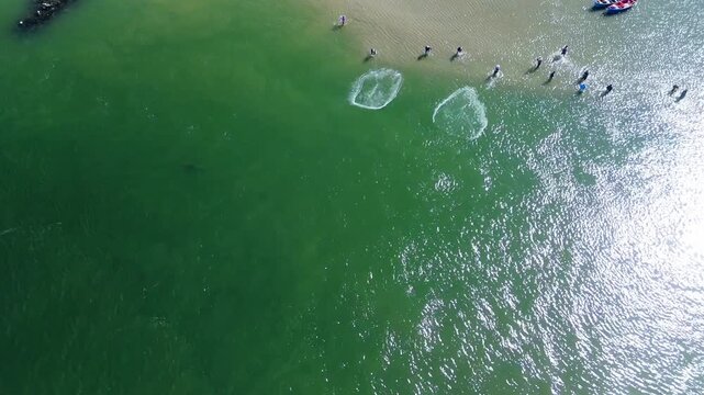 Fishing with dolphins, authentic fishing tradition in Brazil. Aerial view of the group of fishermen collaborating and fishing together with dolphins