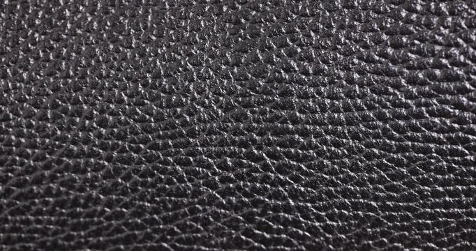 details of a natural black leather bag after prolonged use, details and pieces of natural leather used for the production of items, grainy