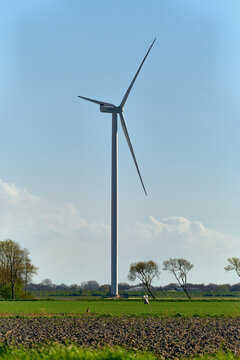 Middenmeer, Netherlands - 14 April 2026: View of a tall Vattenfall wind turbine standing in the Wieringermeer polder landscape under a clear blue sky.