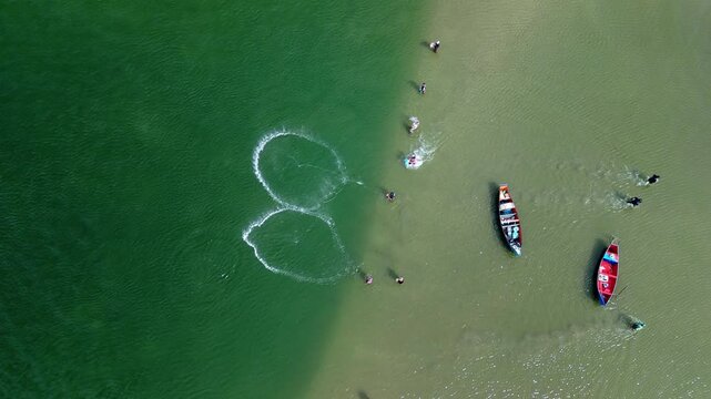 Fishing with dolphins, authentic fishing tradition in Brazil. Aerial view of the group of fishermen collaborating and fishing together with dolphins