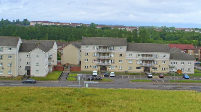 Urban neighborhood showing council housing apartment blocks and a car park in Glasgow, Scotland