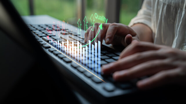 Hands Typing on Keyboard with Data Visualization Graphs Representing Quality Improvement and Growth in Business Metrics. Bitwise.