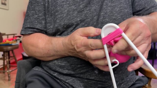 Man Using Clothes Hanger to Tie Knot on a Balloon