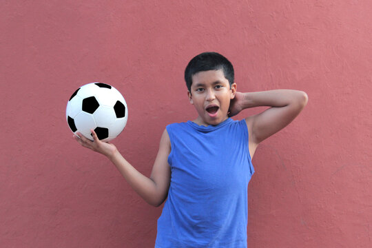 12-year-old Latino boy with dark skin plays with his soccer ball to practice for the game 