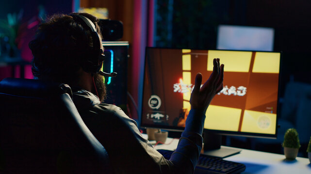 Sad gamer upset after losing online multiplayer action video game championship, being defeated by rivals, man putting face in palms in frustration after seeing game over screen on gaming PC display.
