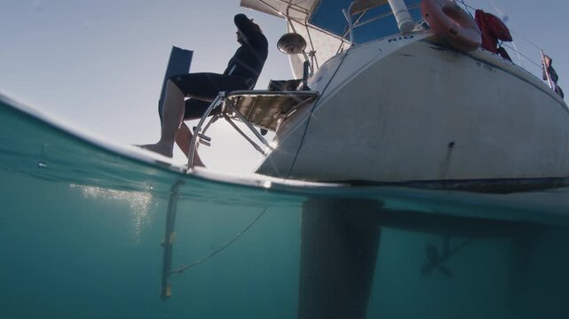 Freediving from the yacht. Freediver prepares for diving in the sea from sailing boat
