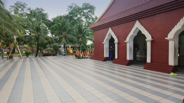 A row of decorative rooster statues are displayed outside Wat Yai Chai Mongkhon in Ayutthaya, Thailand. The statues are colorful and detailed, and they are arranged in a line.
