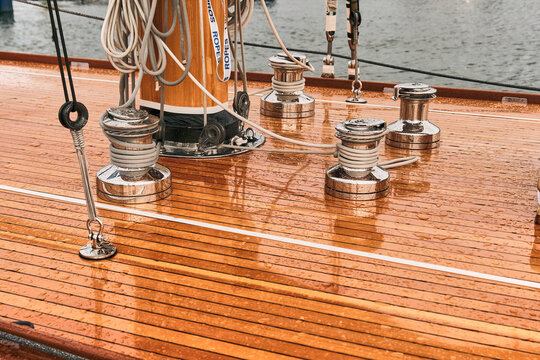 Karlskrona, Sweden - 16 September 2025: View of the polished wooden deck of a vintage racing yacht with chrome winches and rigging in Karlskrona harbour.