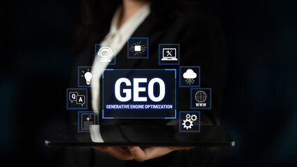Obraz premium Professional Hand Holding Tablet Displaying Generative Engine Optimization (GEO) Concept with Digital Icons and Dark Background Fluxor.